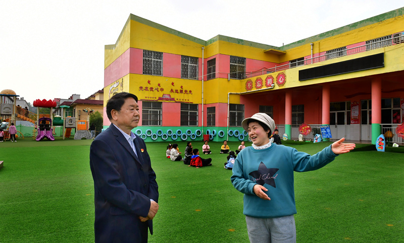3新安县人大代表王慧民（左）了解村教育设施建设情况。_副本